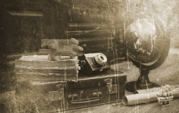 composition on a wooden floor vintage globe with old leather suitcase with objects for travel