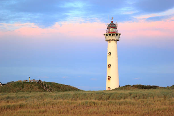Lighthouse at sunset in the twilight. Egmond aan Zee, North Sea, the Netherlands. stock photo