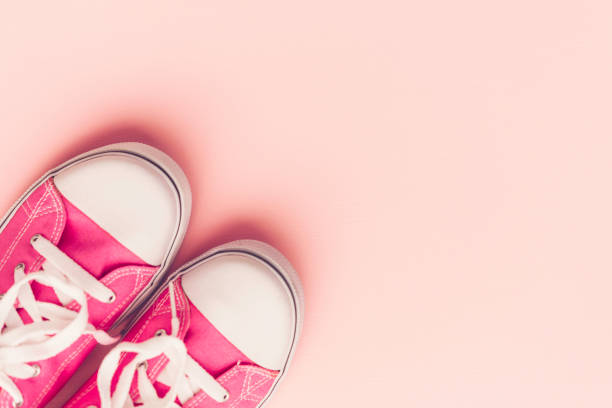 istock Pink canvas shoes with on pink background 859114684