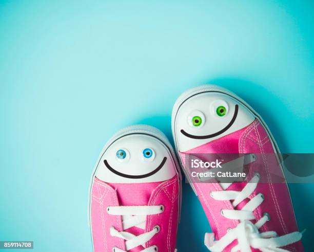 Pink Canvas Shoes With Happy Faces On Blue Background Stock Photo - Download Image Now