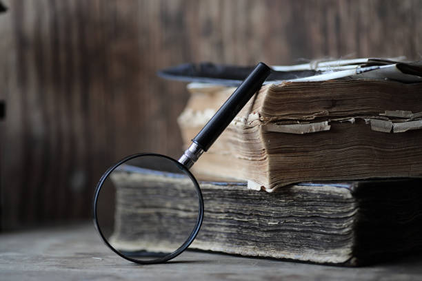 istock Old books on a wooden table and magnifier 859117736