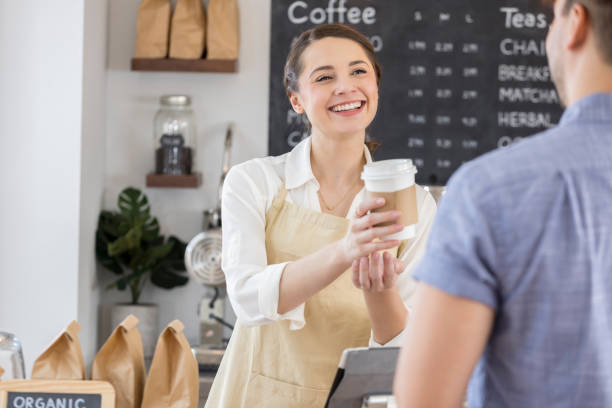 istock Cheerful coffee shop employee hands customer his order 859123394