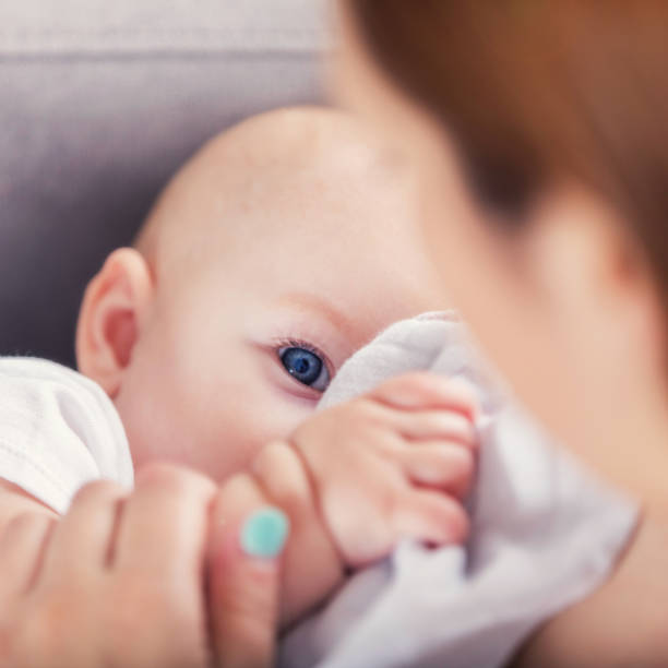 istock Mom breastfeeds adorable blue-eyed baby 859125708
