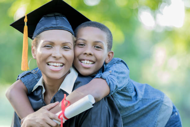 il figlio tween posa con la mamma dopo la cerimonia di laurea al college - graduation student women beauty foto e immagini stock