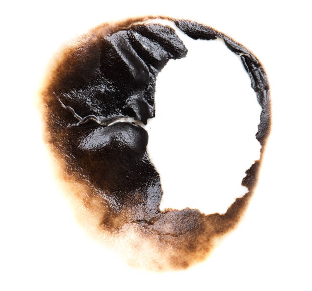 istock burnt hole in a paper 859129348