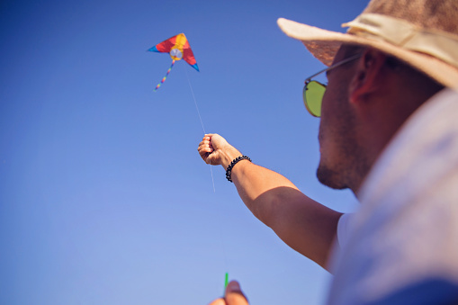 Young man flying kite in nature