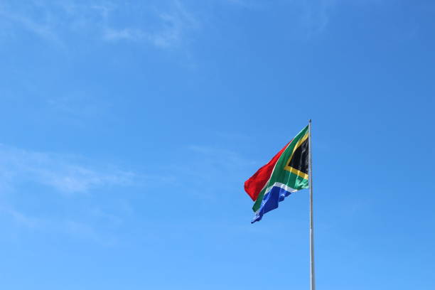 istock A South African flag on a flagpole with a blue sky background. 859138896