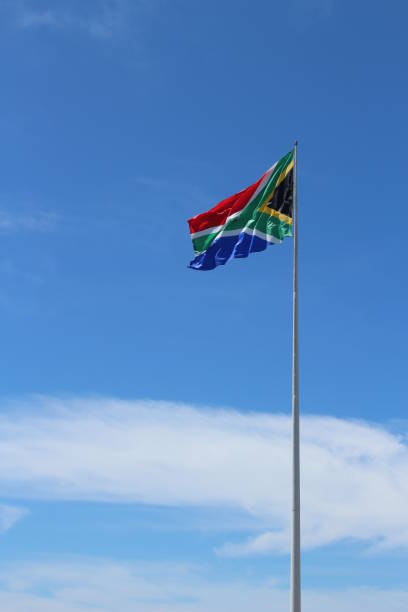 istock A South African flag on a flagpole with a blue sky background. 859138906
