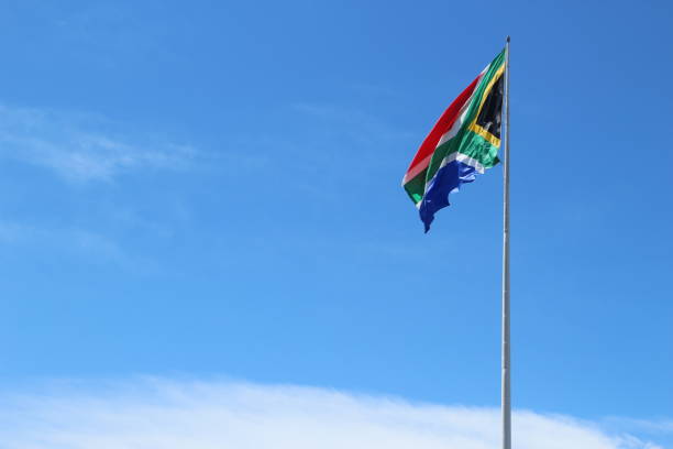 istock A South African flag on a flagpole with a blue sky background. 859139112