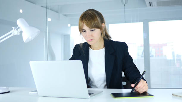 Young Female Designer Working with Graphic tablet on Laptop