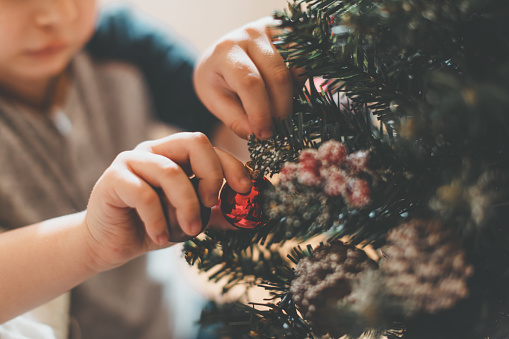 boy decorating christmass tree