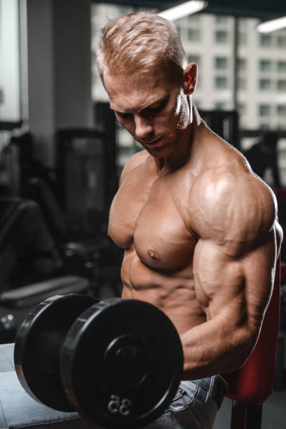 bell'uomo atletico di potenza durante l'allenamento dietetico pompando i muscoli - dumbbell weights weight training biceps femoris foto e immagini stock