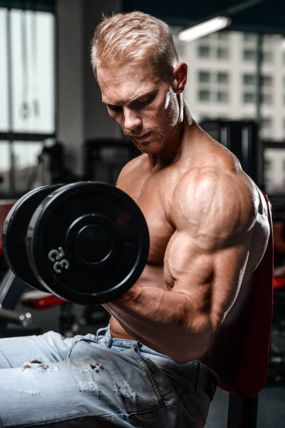 bell'uomo atletico di potenza durante l'allenamento dietetico pompando i muscoli - dumbbell weights weight training biceps femoris foto e immagini stock