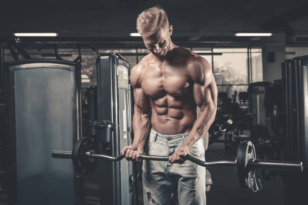 bell'uomo atletico di potenza durante l'allenamento dietetico pompando i muscoli - dumbbell weights weight training biceps femoris foto e immagini stock