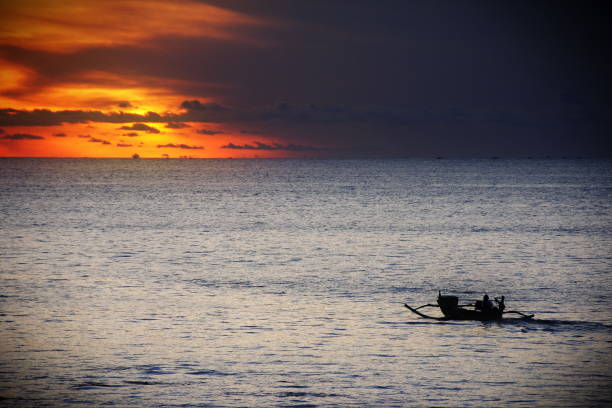 silueta de un jukung al atardecer - jukung fotografías e imágenes de stock