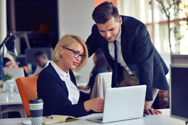 istock Beautiful young business partners are using a laptop, discussing documents and smiling while working in office. 859153054