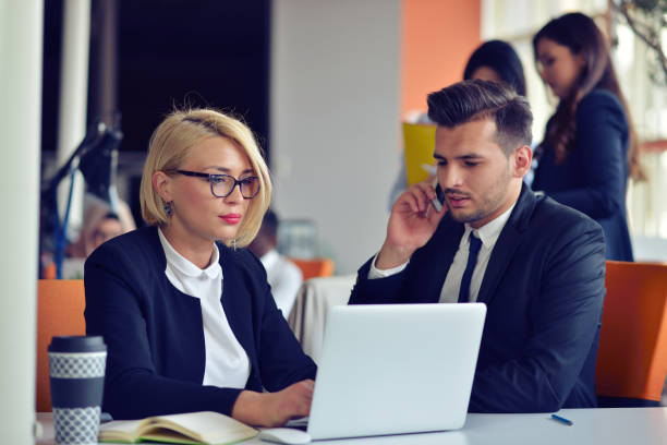istock Beautiful young business partners are using a laptop, discussing documents and smiling while working in office. 859153078
