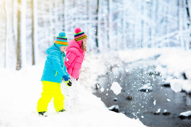 crianças brincando na neve. as crianças brincar ao ar livre na neve do inverno. - 13589 - fotografias e filmes do acervo