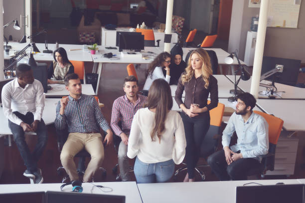 istock business, startup, presentation, strategy and people concept - female on presentation with group of people at office 859156252