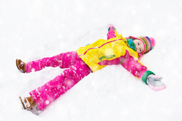 anjo de neve fazendo de criança. crianças brincam em winter park. - 13520 - fotografias e filmes do acervo