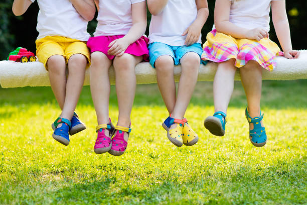 Kids with colorful shoes. Children footwear Footwear for children. Group of preschool kids wearing colorful leather shoes. Sandal summer shoe for young child and baby. Preschooler playing outdoor. Child clothing, foot wear and fashion. sandal stock pictures, royalty-free photos & images