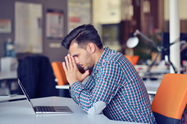 Businessman feeling headache while doing distance work in coffee shop tired with failure of plans