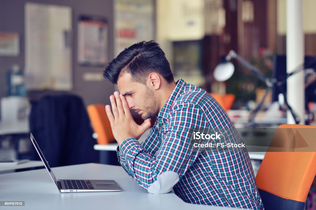 Businessman feeling headache while doing distance work in coffee shop tired with failure of plans Businessman feeling headache while doing distance work in coffee shop tired with failure of plans, male entrepreneur overworked solving problems with startup project exhausted with hard schedule Business Stock Photo