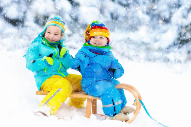 istock Kids on sleigh ride. Children sledding. Winter snow fun. 859157174