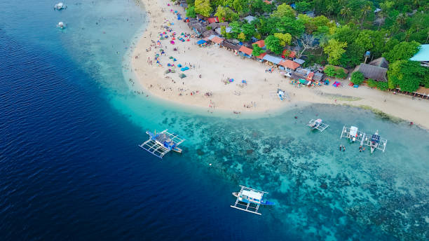 Aerial view of sandy beach with tourists swimming in beautiful clear sea water of the Sumilon island beach landing near Oslob, Cebu, Philippines. - Boost up color Processing. Aerial view of sandy beach with tourists swimming in beautiful clear sea water of the Sumilon island beach landing near Oslob, Cebu, Philippines. - Boost up color Processing. cebu province stock pictures, royalty-free photos & images