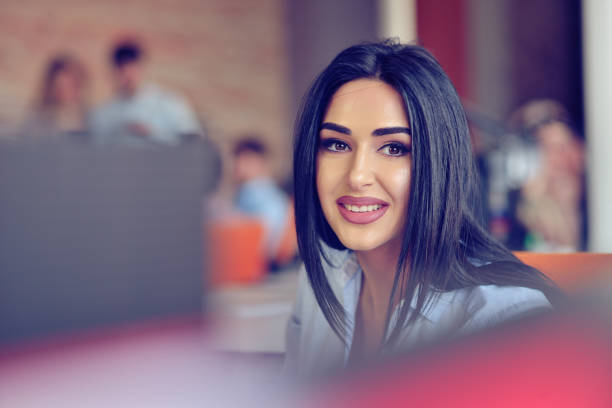 istock Businesswoman sits at a desk in front of a computer 859160104