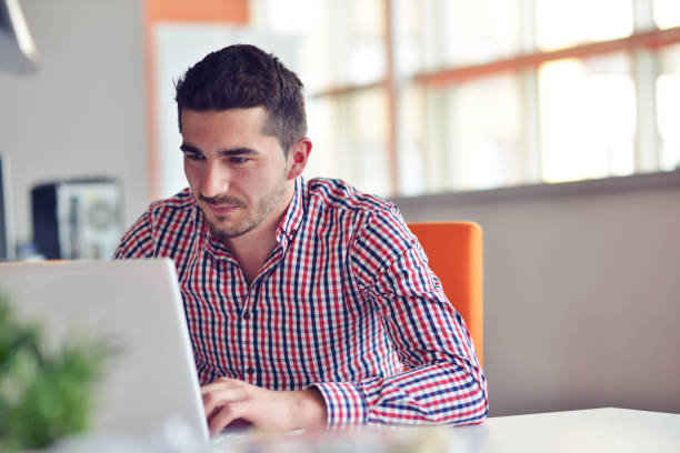 istock Happy young businessman using laptop at his office desk. 859161364