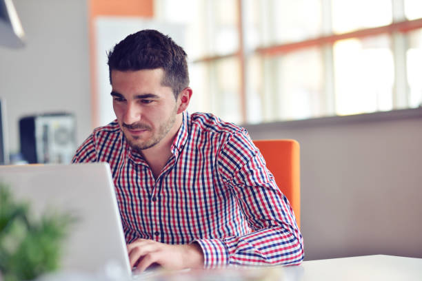 istock Happy young businessman using laptop at his office desk. 859161396