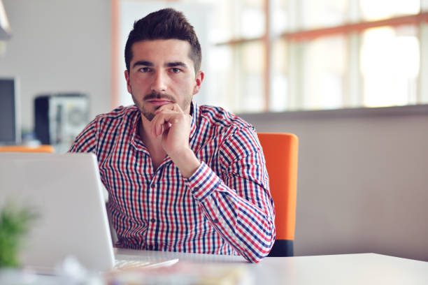 istock Happy young businessman using laptop at his office desk. 859161420
