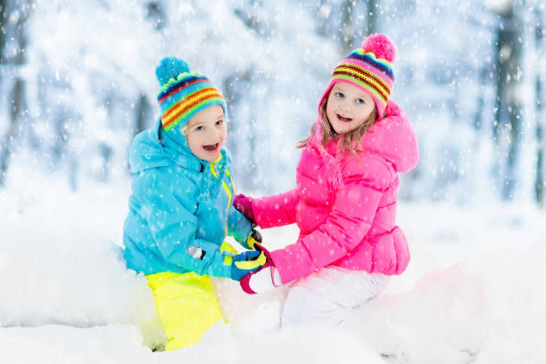 istock Kids playing in snow. Children play outdoors in winter snowfall. 859163782