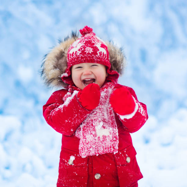 istock Baby playing with snow in winter. 859163812