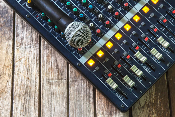 istock Analog audio mixer and microphones on a wooden table. 859179812