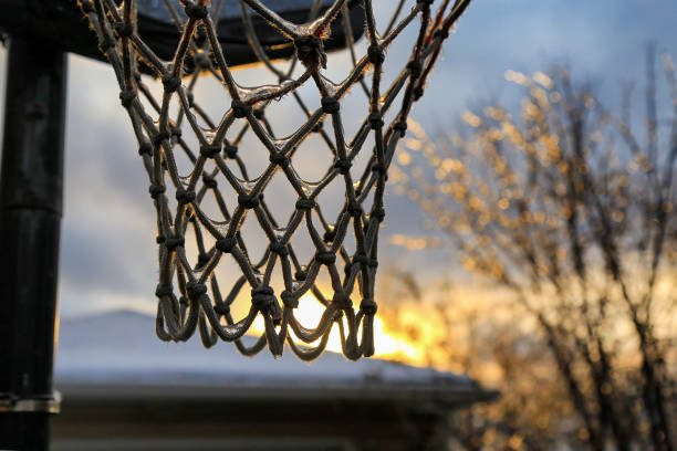Snow-covered white sports basketball court line the road in the residential area of Madison, New Jersey. Top view