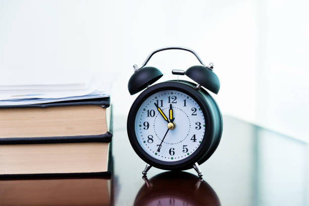 istock Alarm clock and book on the table 859186256