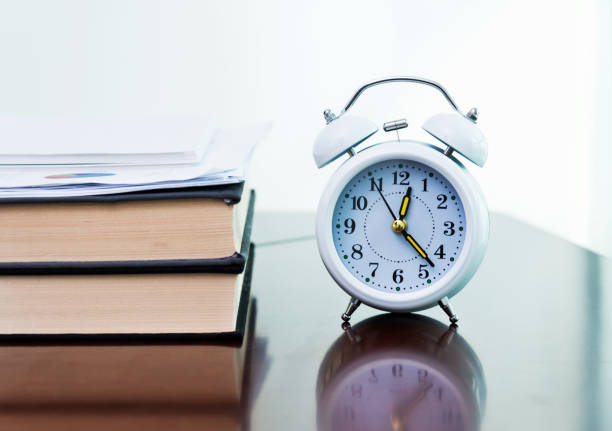 istock Alarm clock and book on the table 859186330
