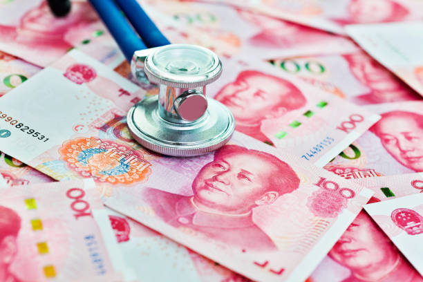 istock Stethoscope on top of Chinese yuan notes 859187468