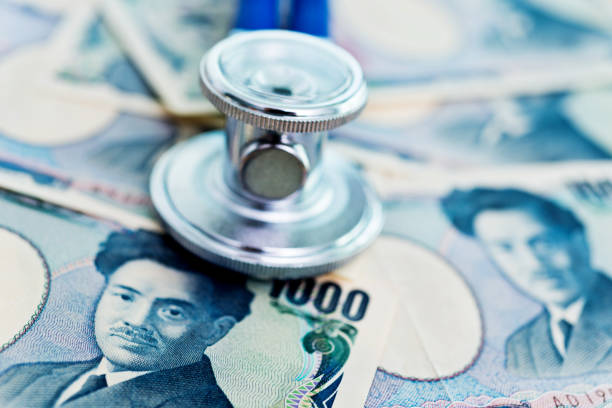 istock Stethoscope on top of Japanese currency 859189156