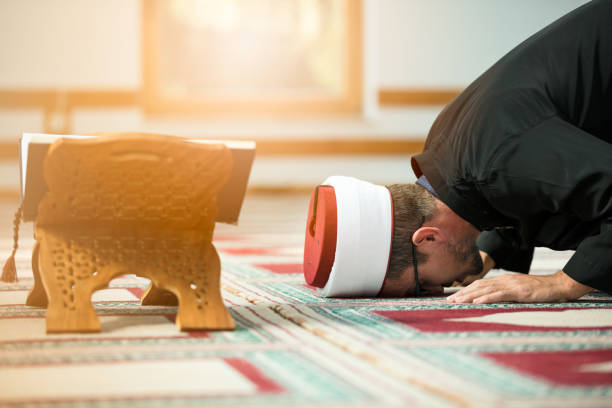 Young Imam praying inside of beautiful mosque