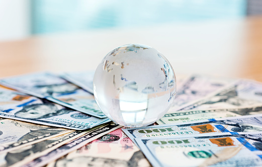 Glass globe and US dollar bills.