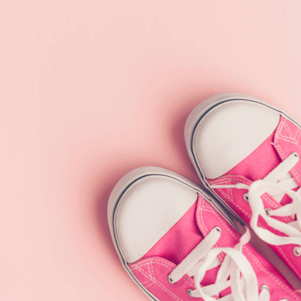 istock Pink canvas shoes with on pink background 859195320