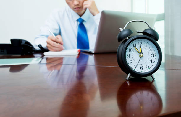 An alarm clock on businessman's desk.