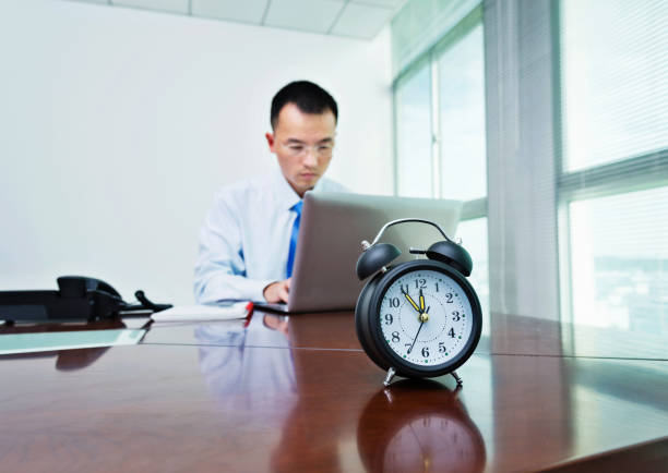 An alarm clock on businessman's desk.