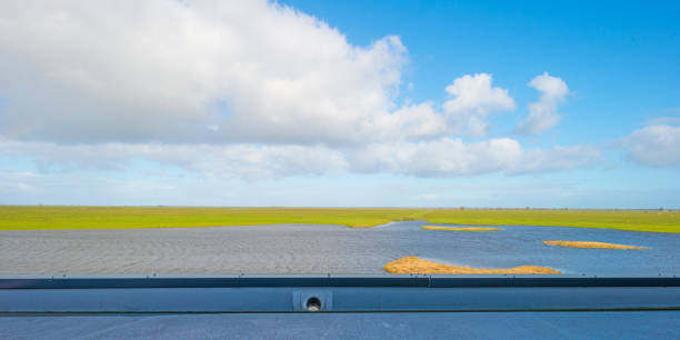 istock Shore of a lake seen from a viewing point below a blue sky 859227154