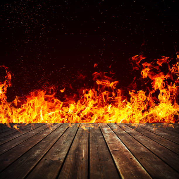 istock Blazing fire and wooden floor texture isolated on black 859229208