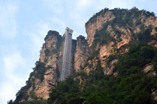 The elevator on a (mountain) rock. Or probably a "sky lift". The elevator on a (mountain) rock. Or probably a "sky lift". It can be found around Wulingyuan scenic area. Pic was taken in Zhangjiajie, September 2017. zhangjiajie photos stock pictures, royalty-free photos & images