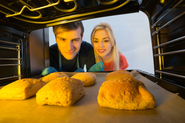 istock Couple Looking At Baking Tray In The Oven 859237608